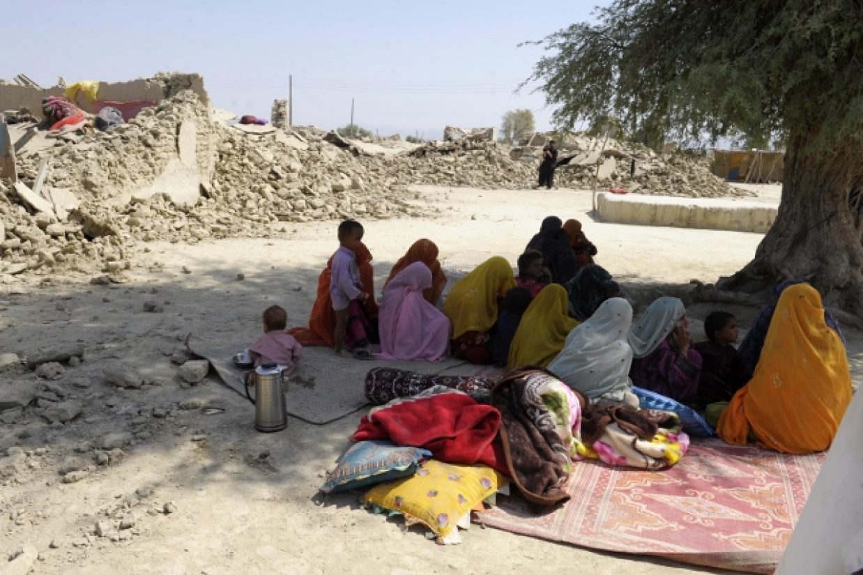 Pakistani women survivors sit near the debris of their destroyed houses in the earthquake-devastated district of Awaran on September 25, 2013.  Desperate villagers in southwest Pakistan clawed through the wreckage of their ruined homes , a day after a hug