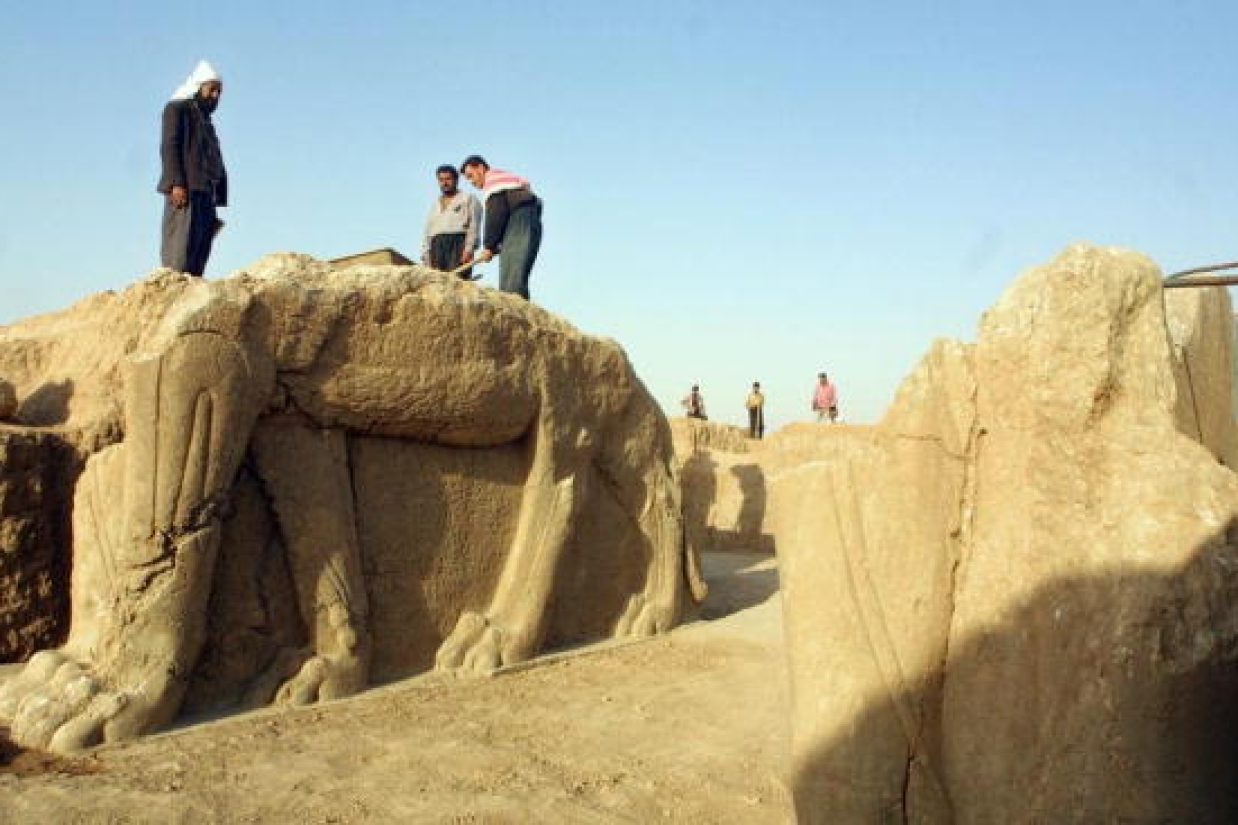 کارگران عراقی در حال تمیز کردن مجسمه گاو بالدار، شهر نمرود در ۳۵ کیلومتری جنوب شرقی موصل، سال ۲۰۰۱ میلادی (KARIM SAHIB/AFP/Getty Images)