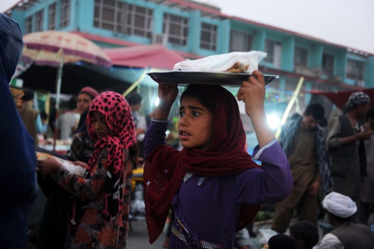 دختری افغان در‎حال فروش نان در یکی‎از خیابان‎های مزارشریف، ۱ ژوئیه ۲۰۱۴. (Farshad Usyan/AFP/Getty Images)