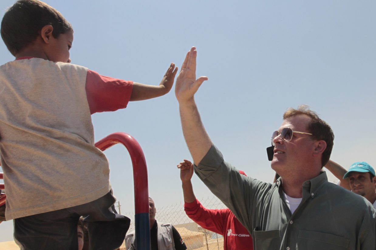 Canadian Foreign Minister John Baird (R) greets a child during a visit with his Jordanian counterpart, Nasser Judeh, to the Zaatari camp for Syrian refugees, 15 kilometres (nine miles) from the kingdom's northern city of Mafraq, near the border with Syria, on August 11, 2012. There are now some 3,000 Syrians sheltering in the desert Zaatari refugee camp that was opened last month to alleviate the humanitarian crisis.  AFP PHOTO/KHALIL MAZRAAWI        (Photo credit should read KHALIL MAZRAAWI/AFP/GettyImages)