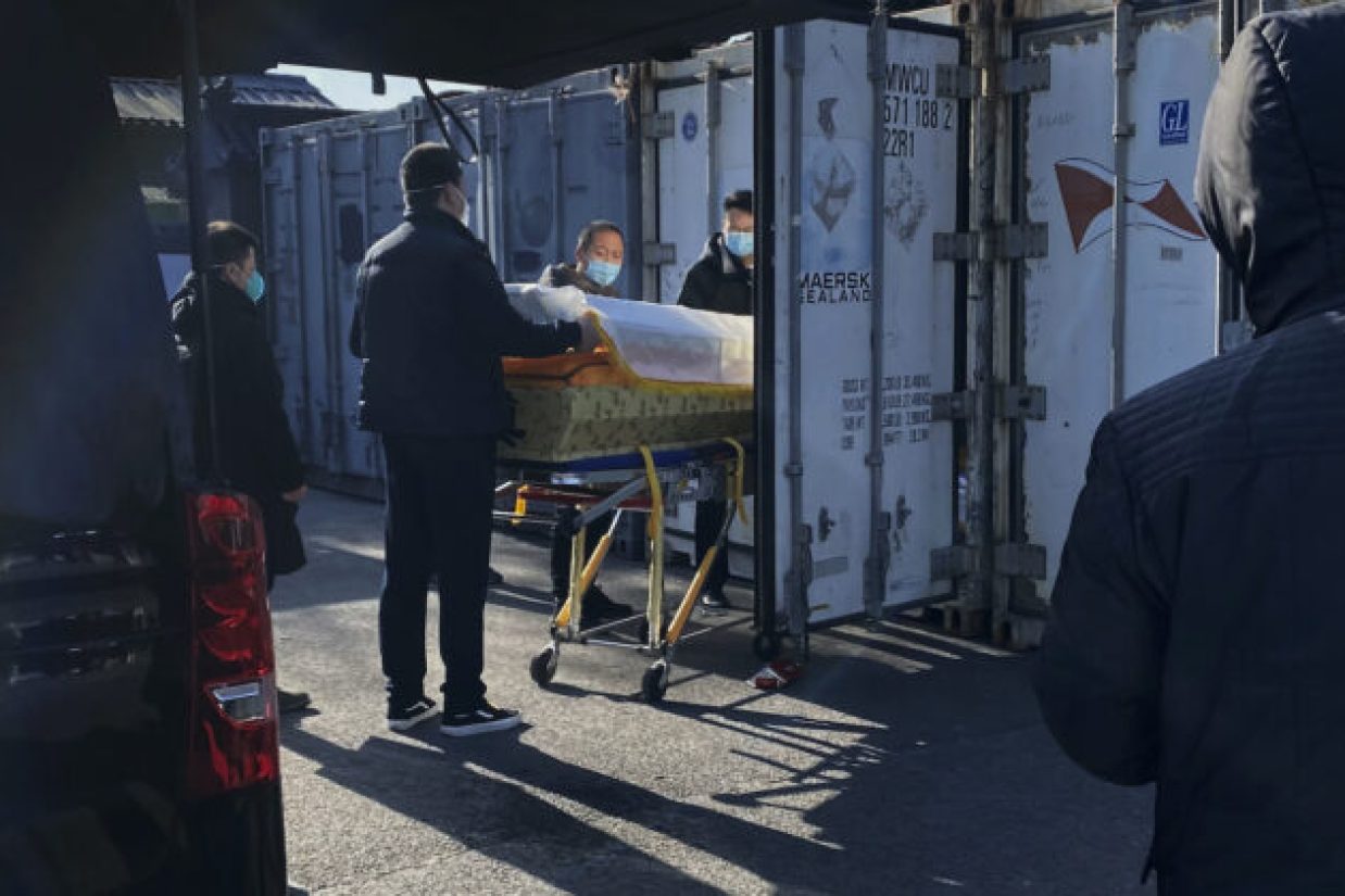 BEIJING, CHINA - DECEMBER 18: A coffin is loaded from a hearse into a storage container at the Dongjiao crematorium and funeral home, one of several in the city that handles COVID-19 cases, on December 18, 2022 in Beijing, China. China's capital has seen a surge in COVID-19 cases since the government lifted its strict zero tolerance measures to contain the virus earlier this month. (Photo by Getty Images)
