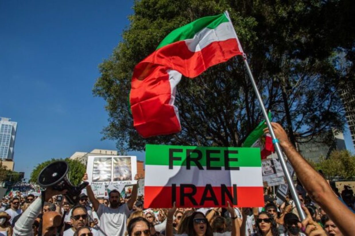 تظاهرکنندگان با پرچم ایران در اعتراض به درگذشت مهسا امینی