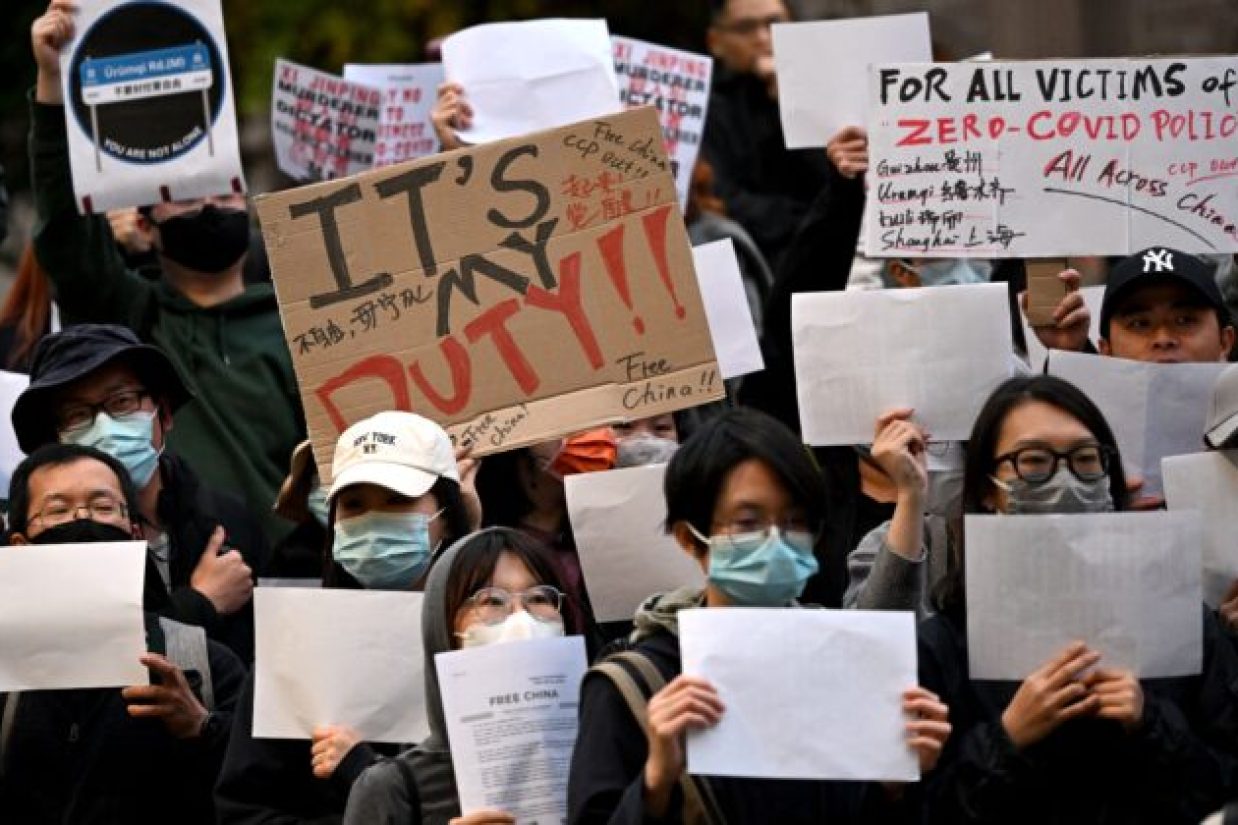 Members of the local Chinese community hold placards at a vigil in support of the protests against Beijing's zero-Covid policy taking place across China, in Melbourne on November 28, 2022. - Hundreds of people have taken to the streets in China's major cities in a rare outpouring of public anger against the state over its zero-Covid policy. (Photo by William WEST / AFP) (Photo by WILLIAM WEST/AFP via Getty Images)